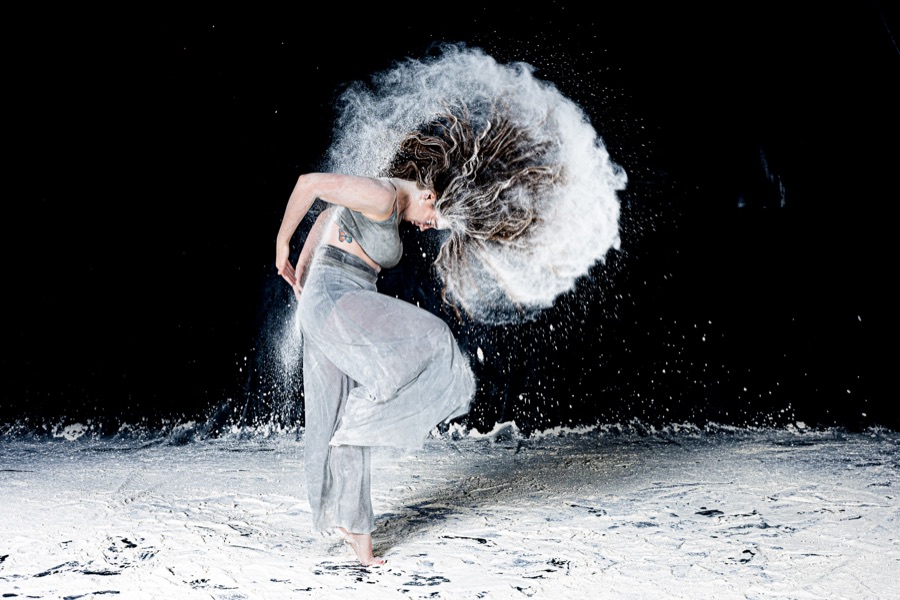 Creative powder dance portrait against a black backdrop